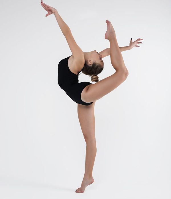 A person in a flowing movement pose, highlighting body flexibility and grace.
