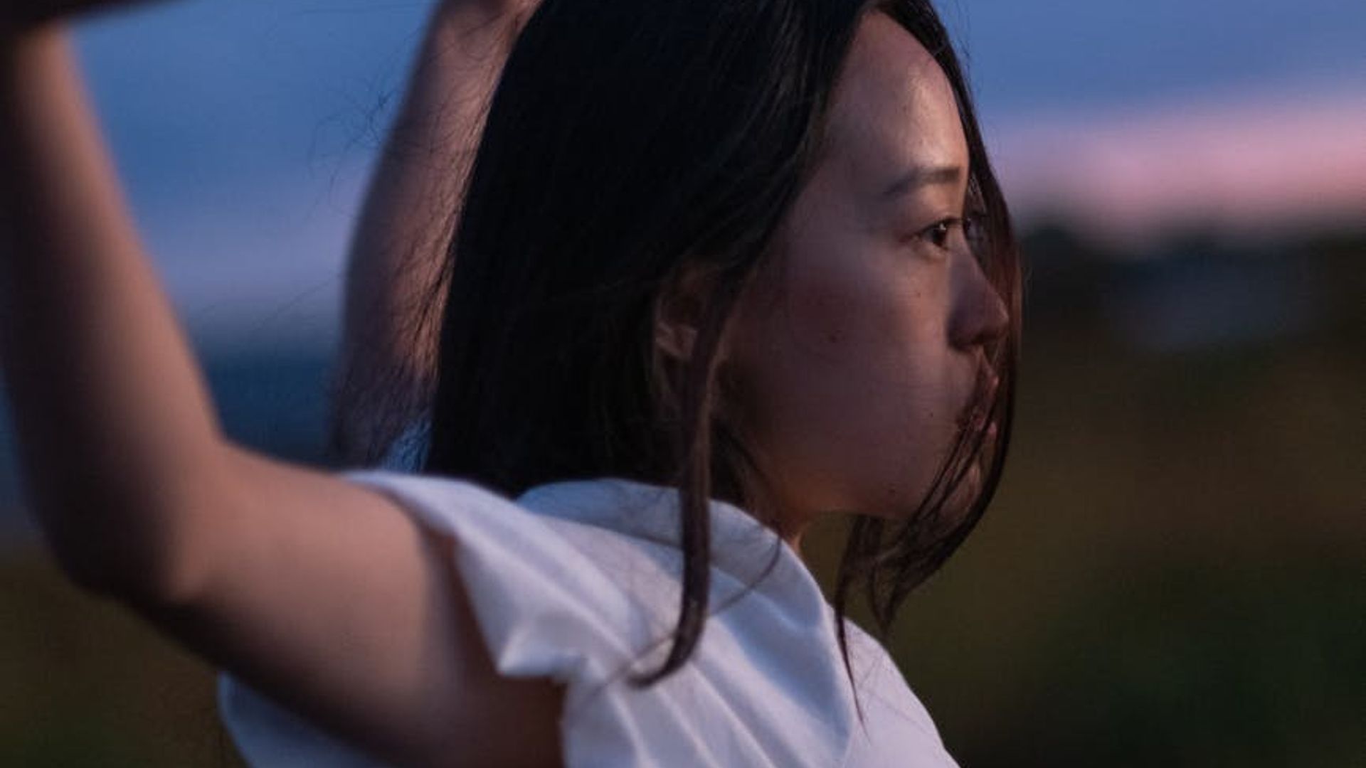 Silhouette of a person in a calm, mindful movement pose against a serene background.